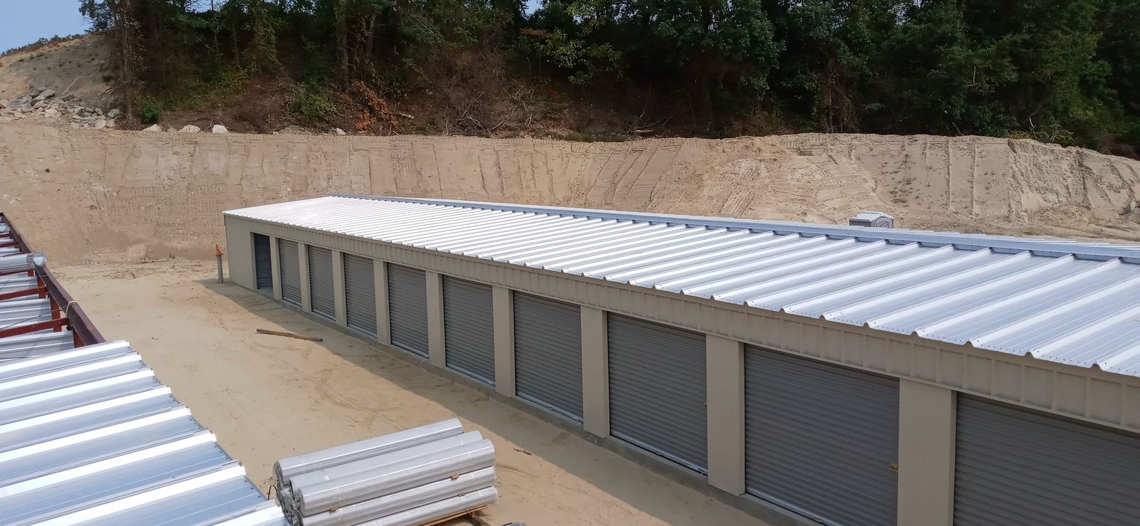 Long self-storage building with a metal roof and a row of roll-up doors